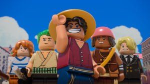 "Group of five LEGO minifigures in colorful outfits posing outdoors with blue sky and clouds, buildings in the background, central figure smiling and wearing a straw hat."